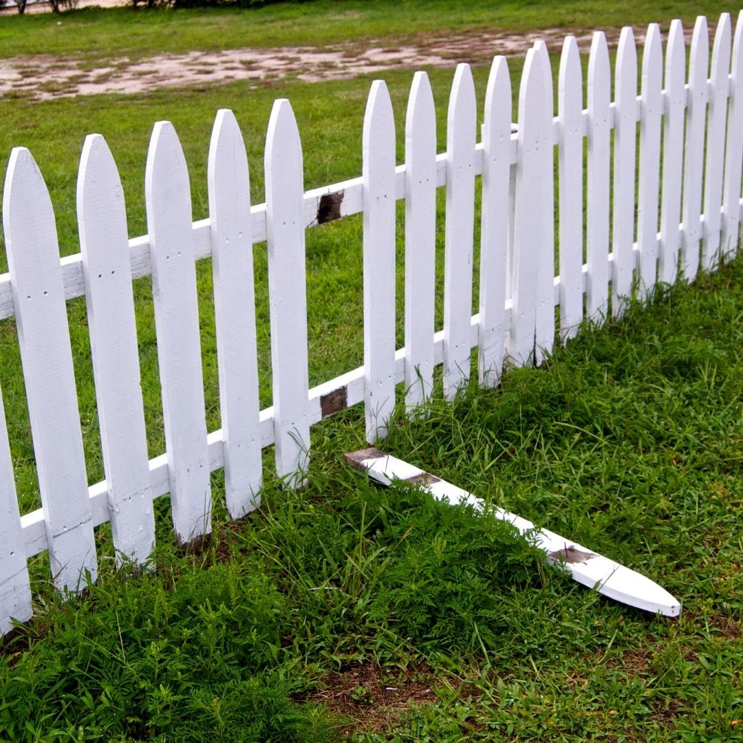 White picket fence with one picket broken